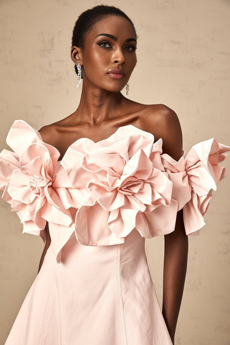 A pink mini dress with an offshoulder neckline featuring threedimensional floral petal details on the bodice and named Juliette
