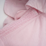 A pink mini dress with an offshoulder neckline featuring threedimensional petal details on the bodice