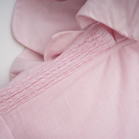 A pink mini dress with an offshoulder neckline featuring threedimensional petal details on the bodice