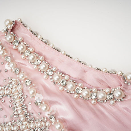 A pink mini dress with pleated skirt and embellished details named Helena