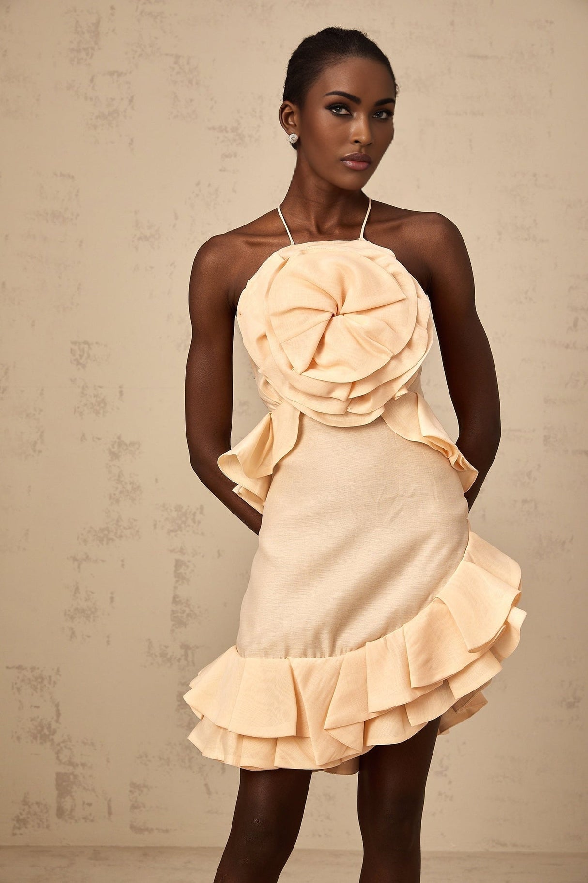 A pink mini dress with ruffled 3d petal details and a short hemline named Ginevra