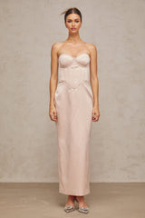 A pink offshoulder maxi dress with a corsetstyle bodice made of satin fabric featuring a long flowing skirt