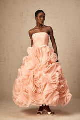 A pink offshoulder midi dress with 3D tulle petals adorning the bodice and skirt creating a romantic and textured appearance
