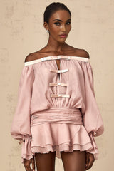 A pink offshoulder mini dress with a bow detail and flounced design worn by a model