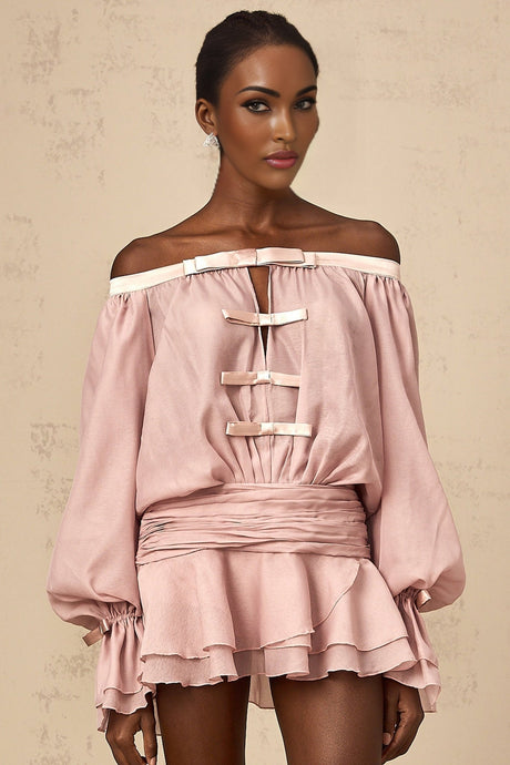 A pink offshoulder mini dress with a bow detail and flounced design worn by a model
