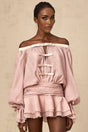 A pink offshoulder mini dress with a bow detail and flounced design worn by a model