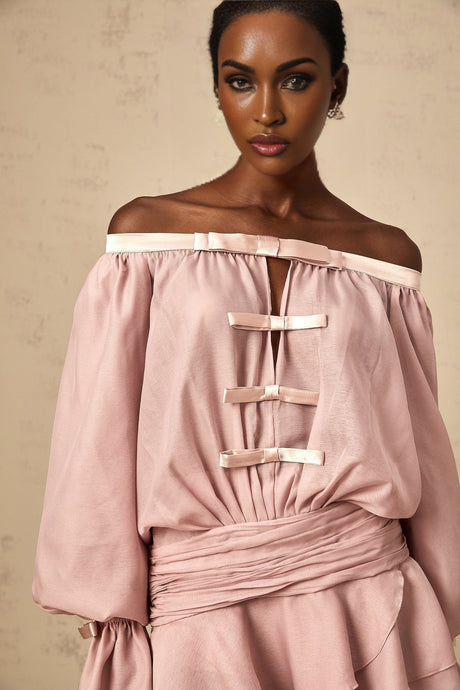 A pink offshoulder mini dress with a bow detail and ruffled hem