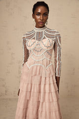 A pink tiered gown with beaded embellishments and semi sheer fabric