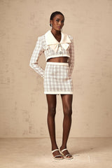 A pink tweed jacket and skirt set with a checkered pattern featuring a matching blazer and mini skirt in a feminine Ludivine style