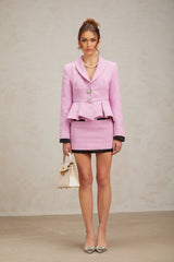 A pink tweed matching set consisting of a top and skirt in a classic style with a feminine touch