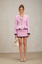 A pink tweed matching set consisting of a top and skirt in a classic style with a feminine touch
