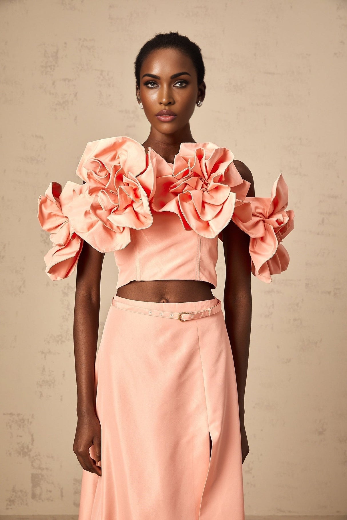 A pink twopiece outfit featuring a top and skirt with floral applique details matching set by Yvette