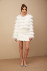 A plush white fur jacket with crystal embellishments and padded design featuring a luxurious Margherita style