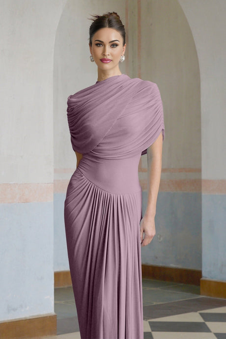 A purple asymmetric maxi dress with pleated details and a long flowing skirt worn by a model standing against a plain background