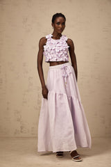A purple twopiece outfit consisting of a sleeveless top and matching skirt adorned with faux flowers creating a floral pattern throughout the set
