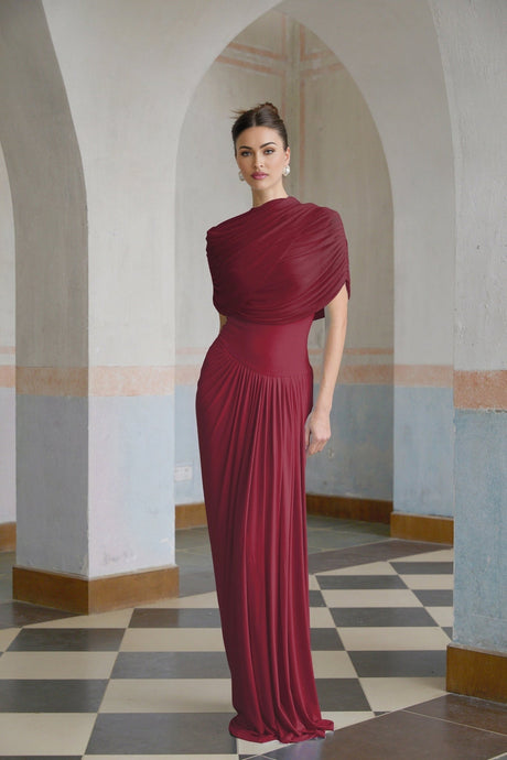 A red asymmetric maxi dress with pleated details and a long flowing skirt