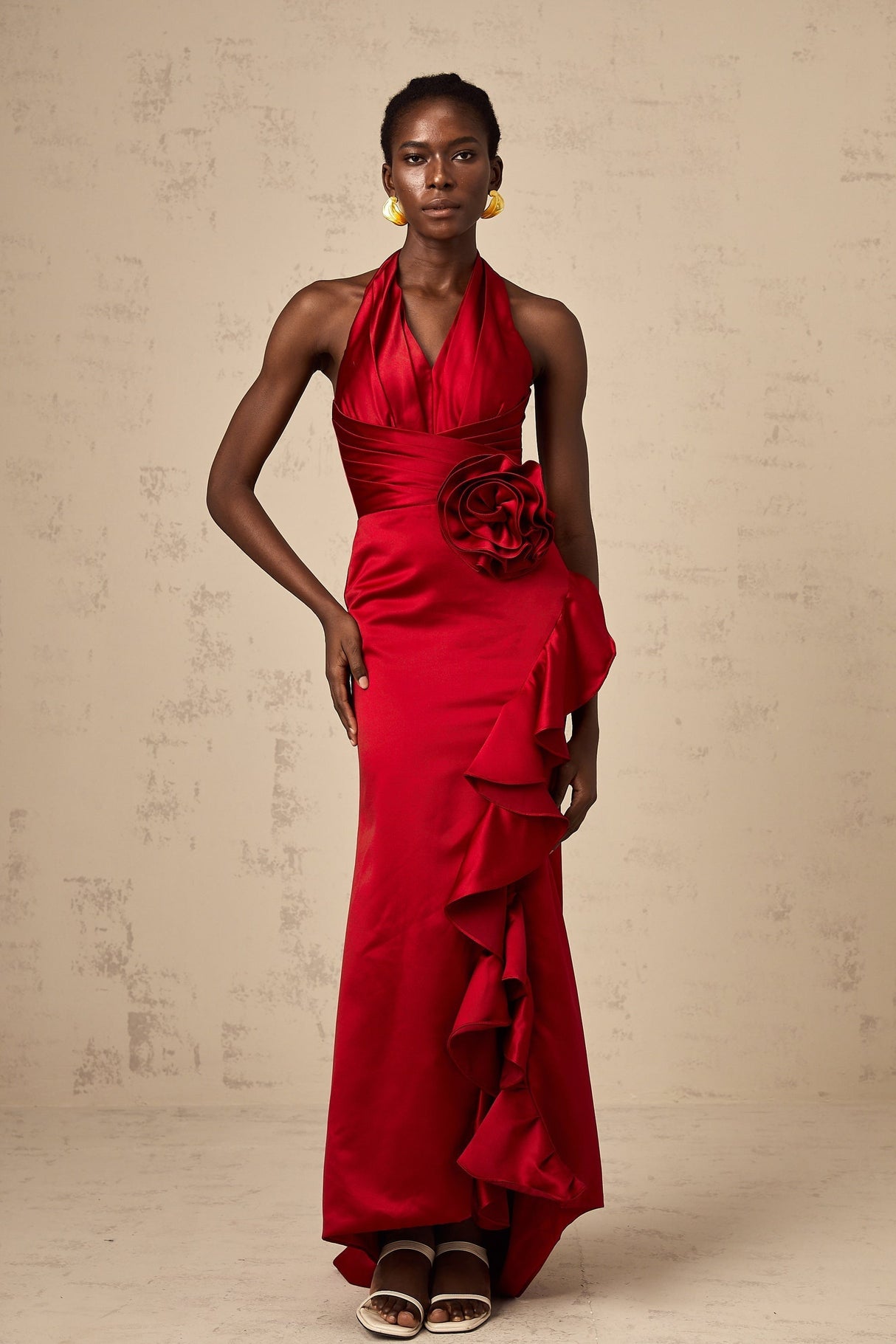 A red halterneck maxi dress featuring 3D petal ruffles and a flowing long skirt