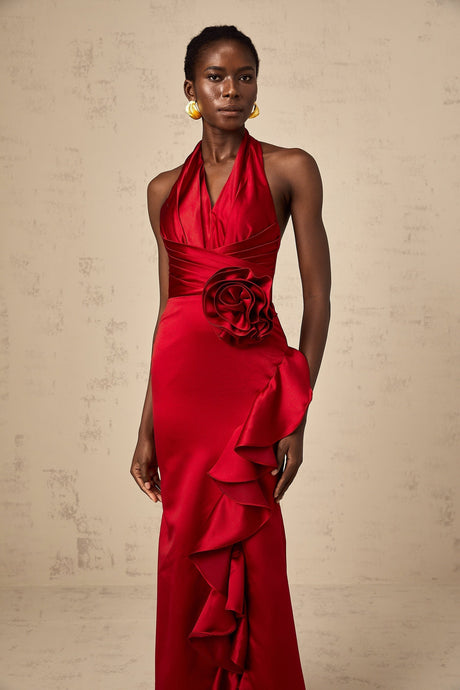 A red halterneck maxi dress with 3D petal ruffles cascading down the length featuring a fitted bodice and flowing skirt