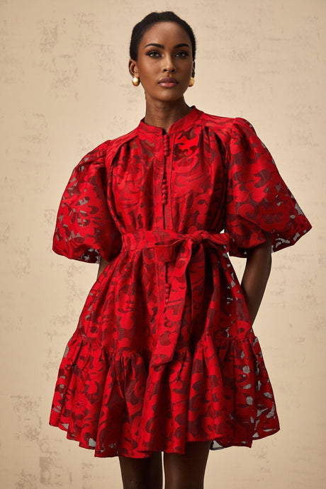 A red jacquard mini dress with a semi sheer fabric featuring a floral pattern and a short hemline