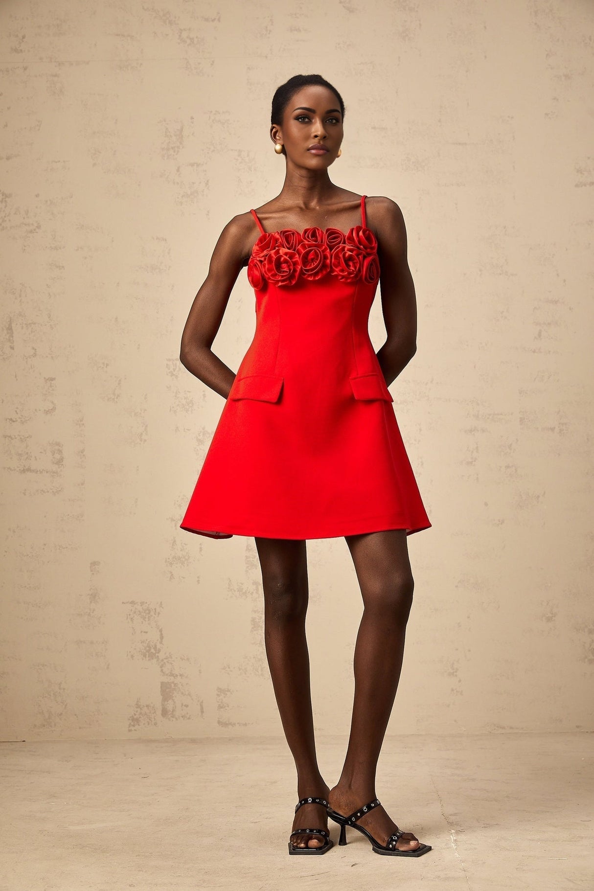 A red mini dress with a flared skirt featuring rose appliqués on the bodice