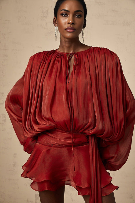 A red mini dress with a fully pleated design and ruffled details featuring a short hemline and feminine silhouette