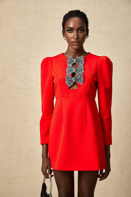 A red mini dress with a split skirt featuring a studded bow accent and a short hemline