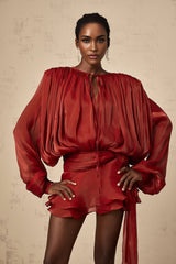 A red mini dress with full pleats and ruffled details named Eugenie