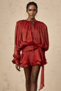 A red mini dress with full pleats and ruffles named Eugenie