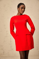 A red mini dress with long sleeves and a bowknot detail worn by a model against a plain background