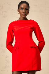 A red mini dress with long sleeves and a decorative bow detail at the neckline named Magali
