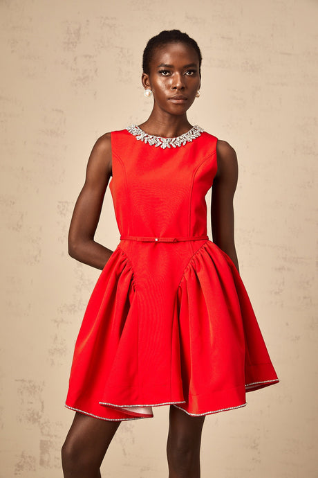 A red mini dress with pleated fabric and embellishments named Leonie featuring a short hemline and decorative details