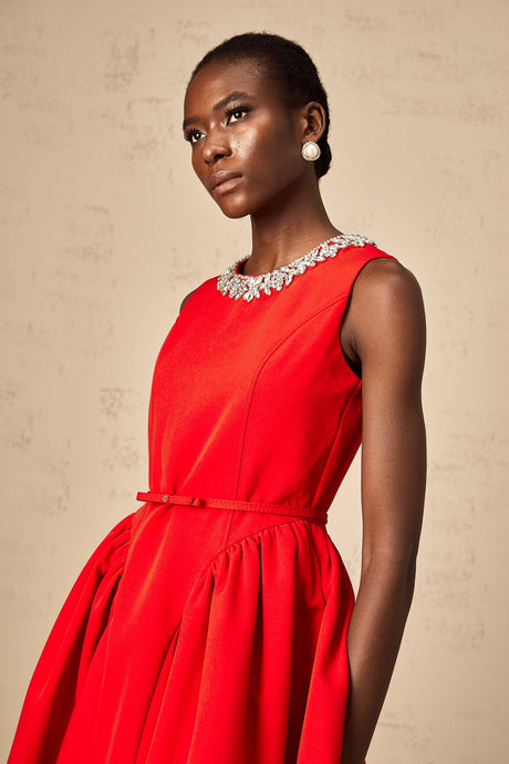 A red mini dress with pleating and embellishments named Leonie featuring a short hemline and decorative details