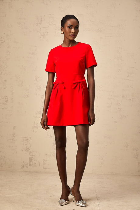 A red mini dress with short sleeves and a bow detail worn by a model