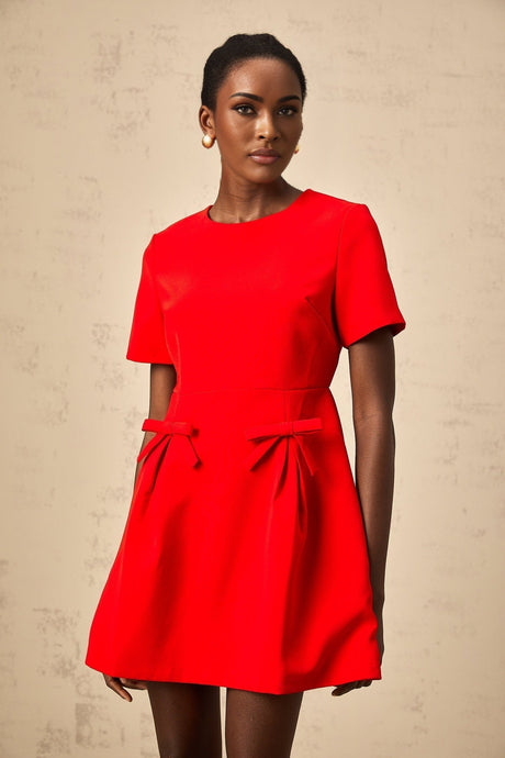A red mini dress with short sleeves and a bow detail worn by a model