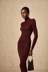 A red semi sheer knitted midi dress with long sleeves and a form fitting silhouette