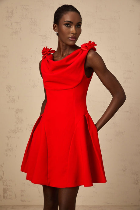 A red sleeveless mini dress with faux flower details worn by a model standing against a plain background
