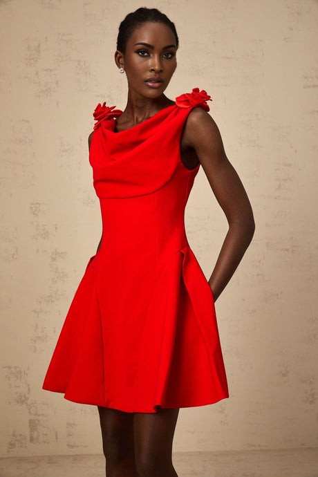 A red sleeveless mini dress with faux flower embellishments on a model against a plain background
