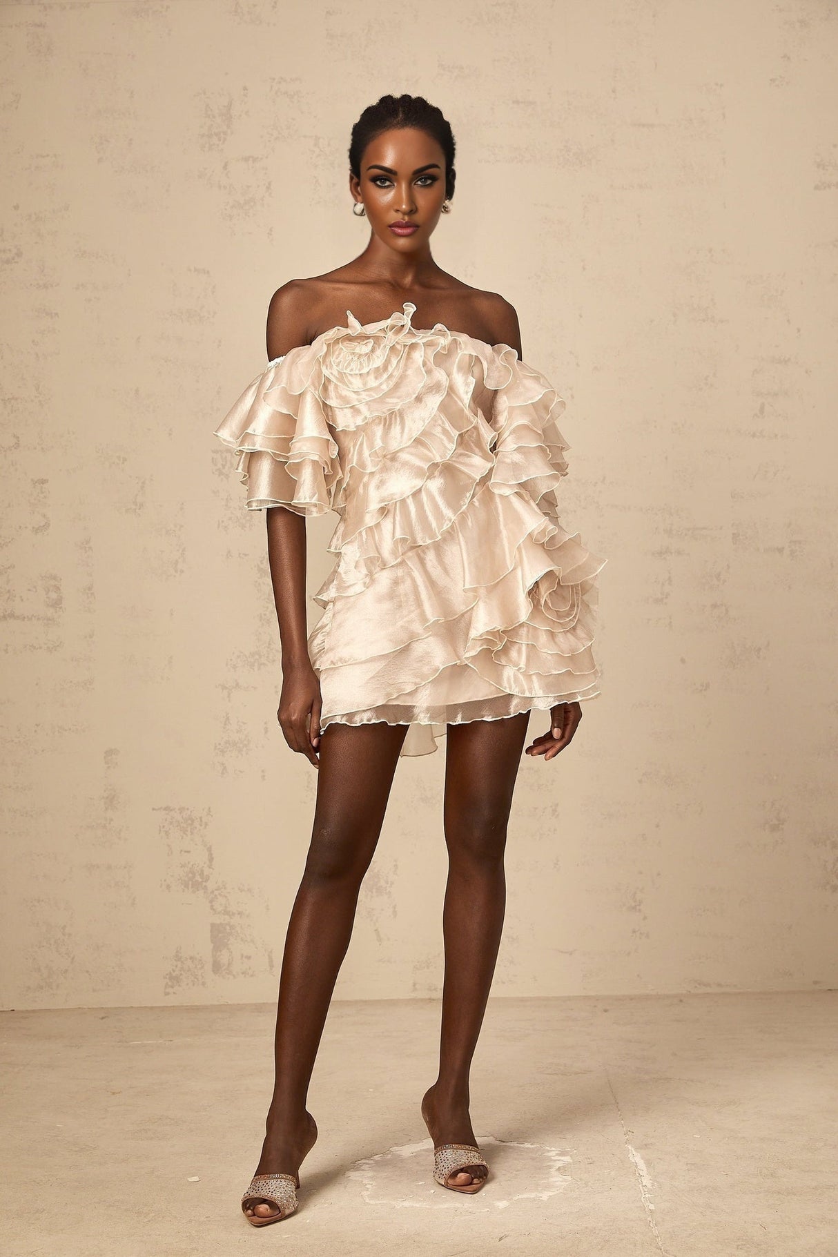 A short asymmetric mini dress in neutral tones featuring a cerise pink flounce detail and one shoulder design