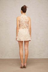 A short beige lace mini dress with delicate floral appliques featuring a feminine silhouette and neutral color palette