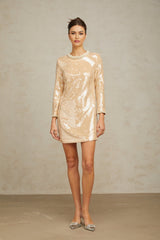 A short beige mini dress adorned with faux pearls and sequins in neutral tones featuring a sleeveless design and form fitting silhouette