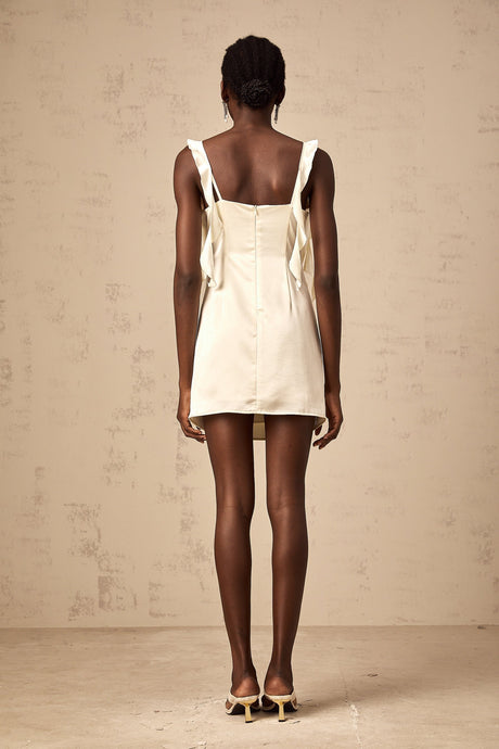 A short beige mini dress with butterfly prints and draped fabric details featuring a sleeveless design and a flowing silhouette