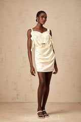 A short beige mini dress with butterflyinspired draping and a neutral color palette