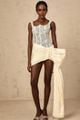 A short beige mini dress with floral lace pattern featuring a bowknot detail and a pencil skirt silhouette