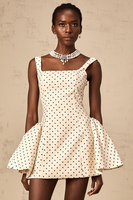 A short beige mini dress with polka dots and puff sleeves in a neutral color palette