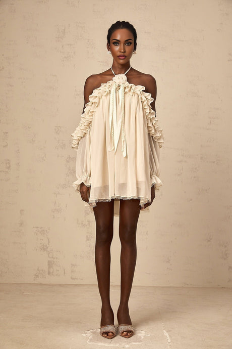 A short beige mini dress with ruffled details and delicate floral appliques scattered across the fabric