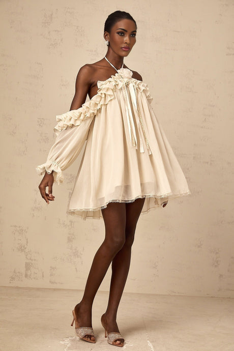 A short beige mini dress with ruffled details and floral appliques in neutral tones