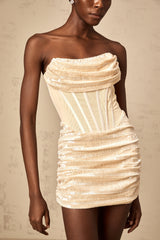 A short beige sequined tulle mini dress with spaghetti straps and a flared skirt sparkling in neutral tones