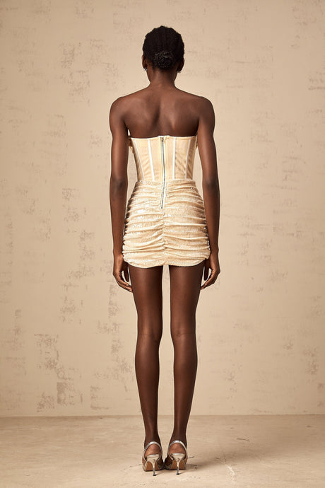 A short beige tulle mini dress with allover sequin embellishment and a sleeveless design featuring a fitted silhouette and scoop neckline