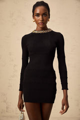 A short black dress with ribbed texture and sequin embellishments featuring a closefitting silhouette and mini length