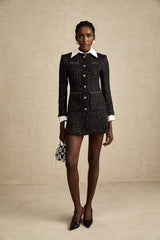 A short black dress with tweed fabric and sequin panels in a mini length featuring an Audrey style design